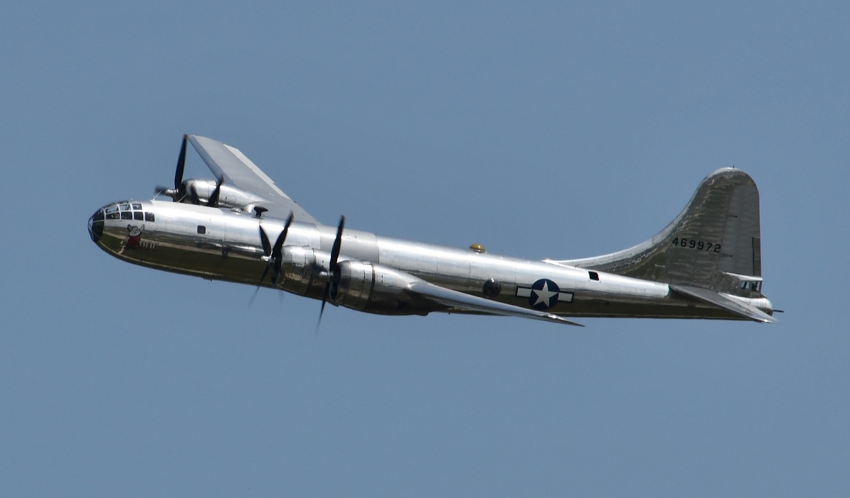 B-29 Superfortress Doc airborne in flight, side or three-quarter view showing the polished silver fuselage and four engines, taken at an airshow