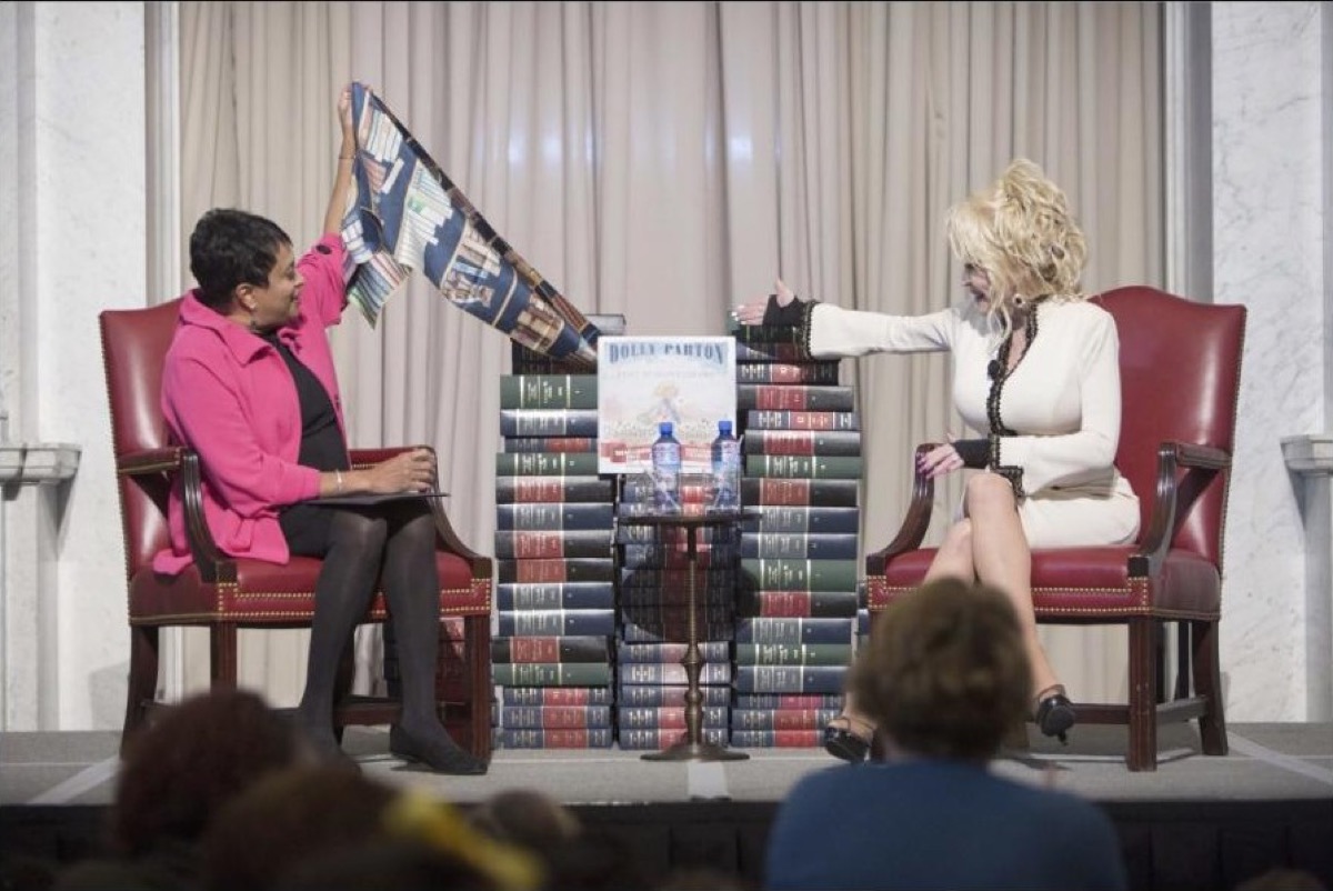 Librarian of Congress Carla Hayden and Dolly Parton unveiling a stacked display of Imagination Library books at the Library of Congress