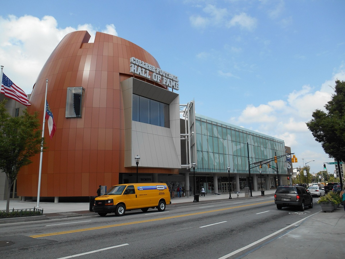 The Chick-fil-A College Football Hall of Fame building in Atlanta, with its distinctive orange football-helmet-shaped exterior and rooftop sign