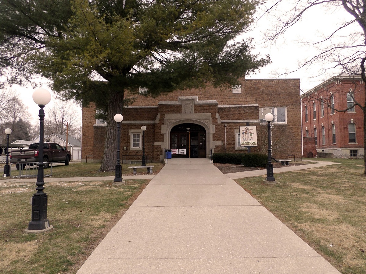 Exterior of the historic 1921 Hoosier Gym brick building in Knightstown, Indiana, with its name and Hoosiers movie signage visible