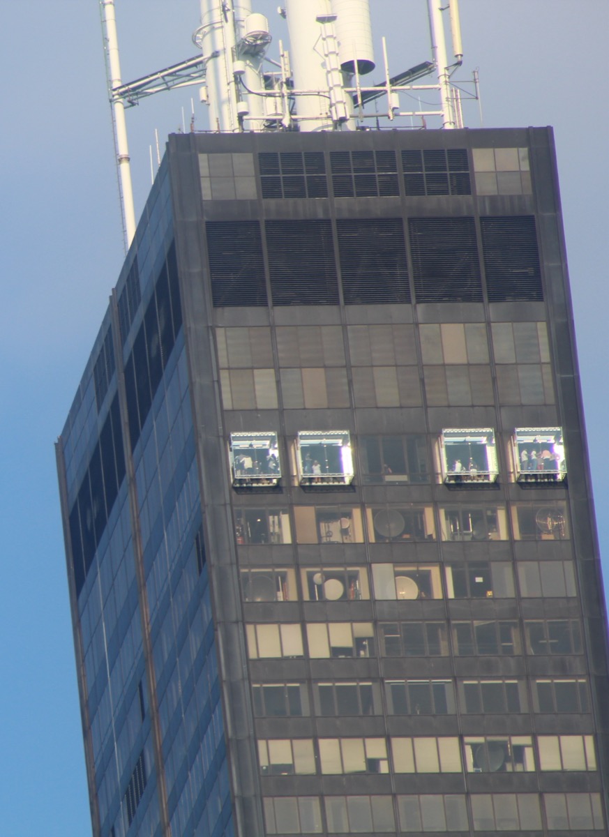 Exterior view of the Willis Tower (Sears Tower) showing the glass Ledge boxes protruding from the 103rd floor facade, high above the Chicago skyline