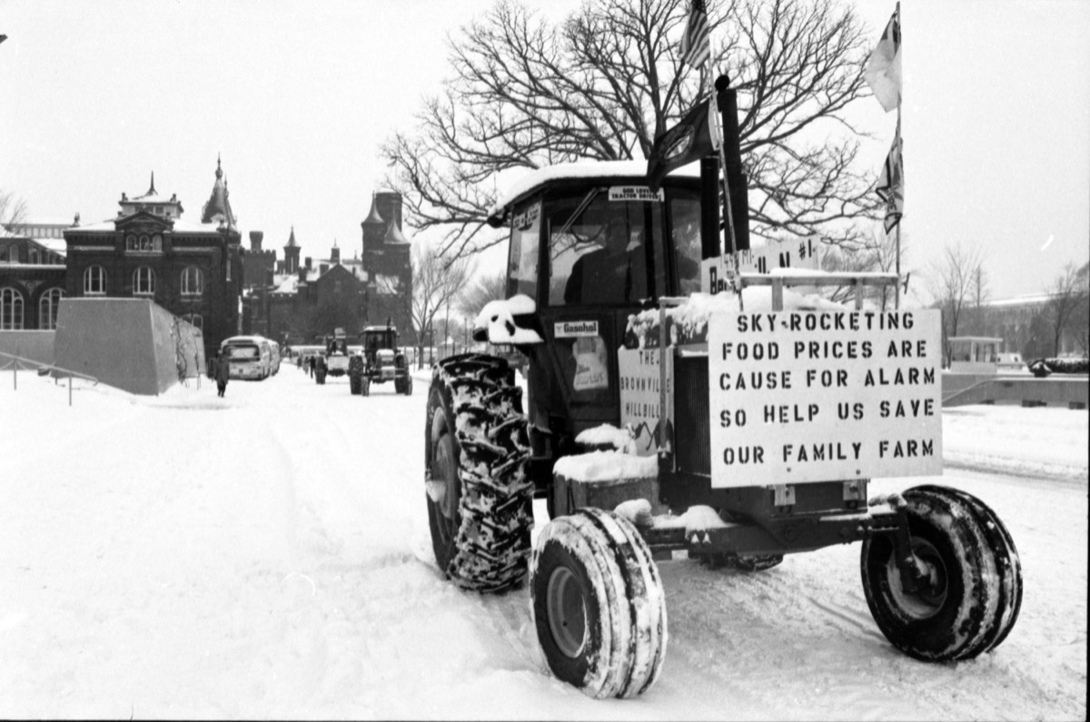 Snow-covered tractors of the American Agriculture Movement lined up on the National Mall during the February 1979 blizzard, with the Smithsonian Castle in the background