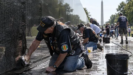 The Vietnam Veterans Memorial Wall gets washed by hand. Vietnam veterans get down on the granite and